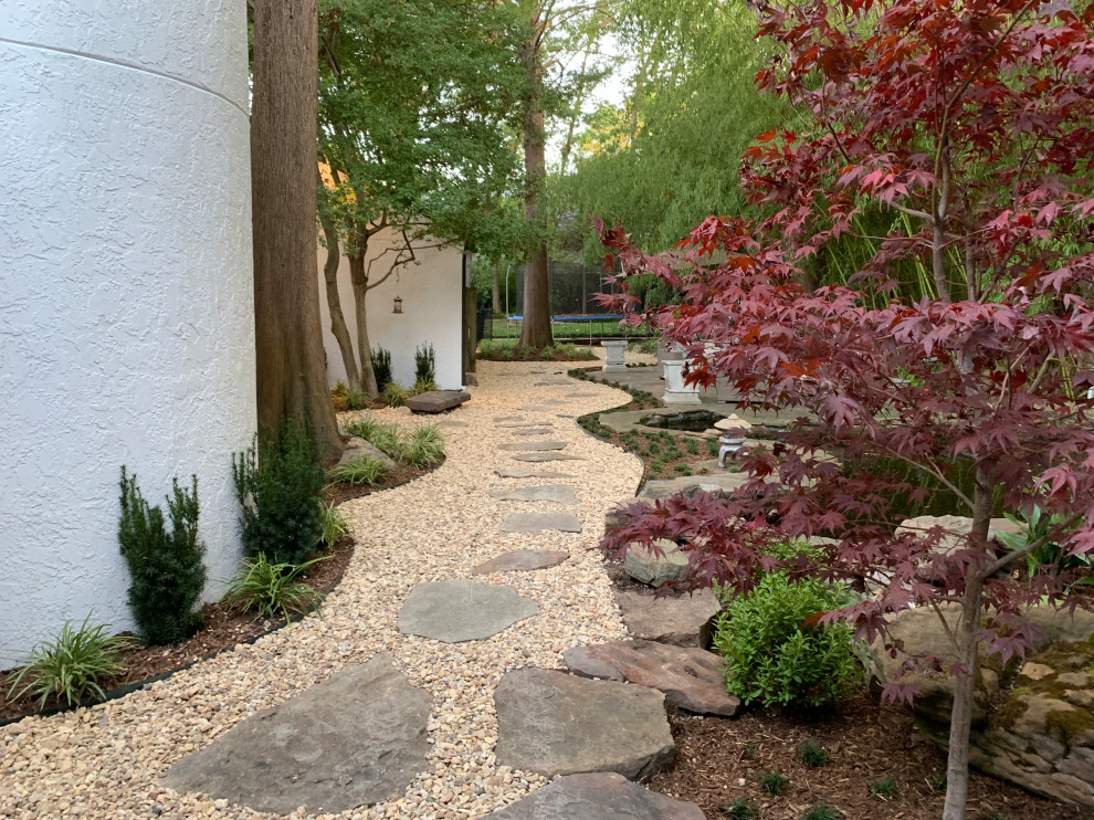 Design ideas for an asian backyard shaded xeriscape for summer in Dallas with a garden path, river rock and a stone fence.