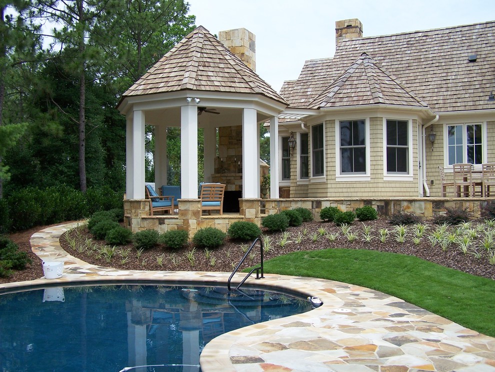 Inspiration for a traditional pool in Raleigh with natural stone pavers.