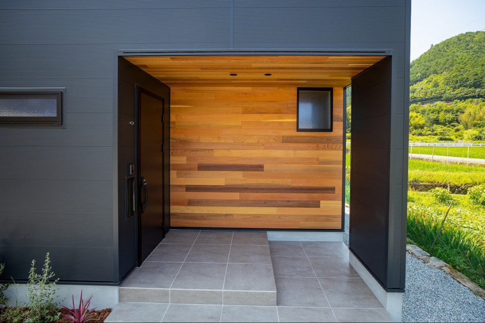 Photo of an entryway in Kyoto with black walls, a single front door, a black front door and wood walls.