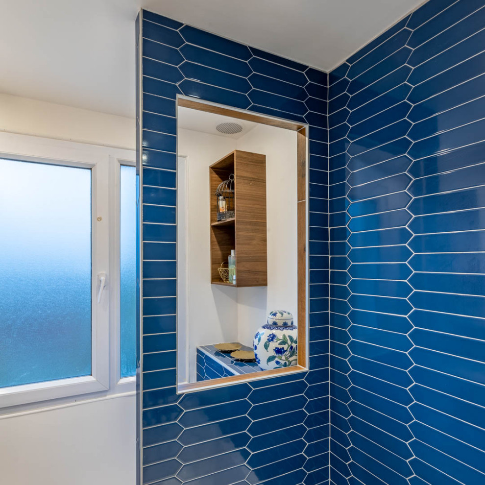 Inredning av ett modernt litet vit vitt toalett, med luckor med profilerade fronter, skåp i mörkt trä, en vägghängd toalettstol, blå kakel, keramikplattor, vita väggar, marmorgolv, ett konsol handfat, bänkskiva i akrylsten och blått golv