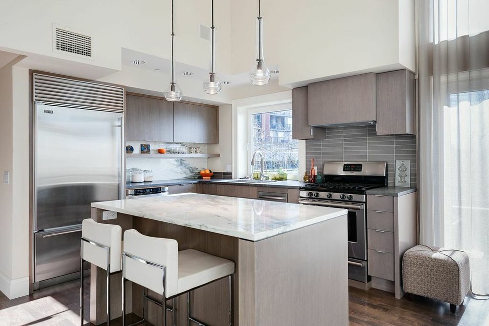 Inspiration for a contemporary l-shaped kitchen in Seattle with flat-panel cabinets, grey cabinets, grey splashback, stainless steel appliances, with island and grey benchtop.