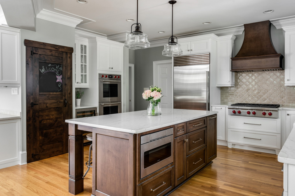 Photo of a mid-sized transitional l-shaped eat-in kitchen in Charlotte with a farmhouse sink, shaker cabinets, white cabinets, quartz benchtops, brown splashback, porcelain splashback, stainless steel appliances, light hardwood floors, with island, brown floor and yellow benchtop.