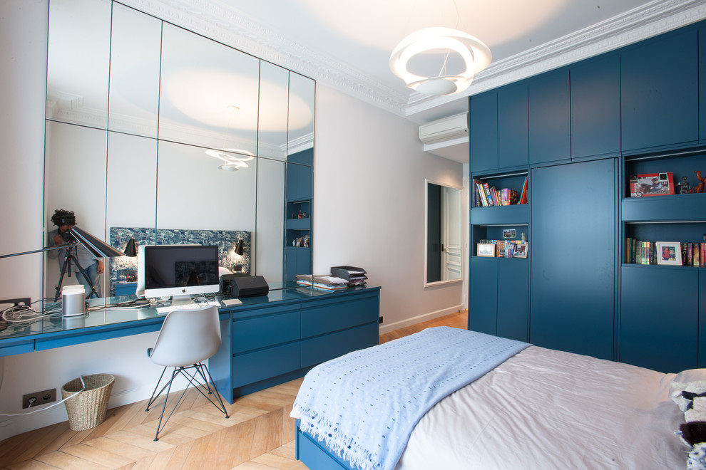 This is an example of a large contemporary kids' room for boys in Paris with white walls and medium hardwood floors.