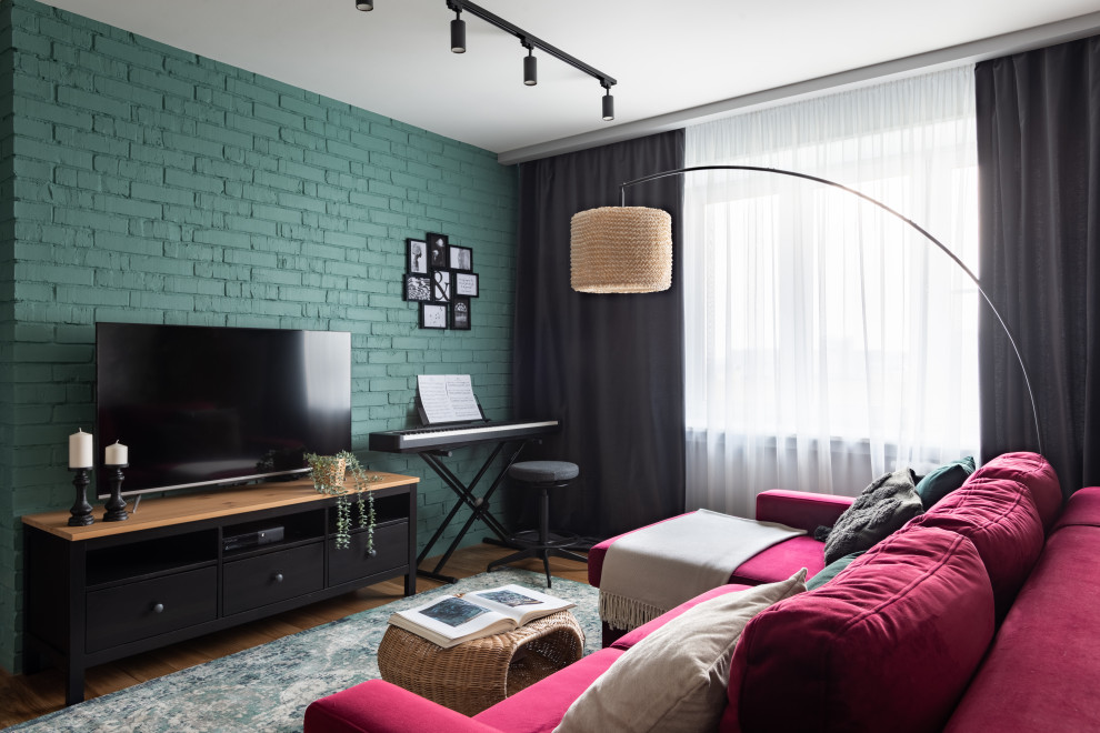 Стильный дизайн: маленькая открытая гостиная комната с музыкальной комнатой, зелеными стенами, паркетным полом среднего тона, отдельно стоящим телевизором, обоями на стенах и бордовым диваном для на участке и в саду - последний тренд