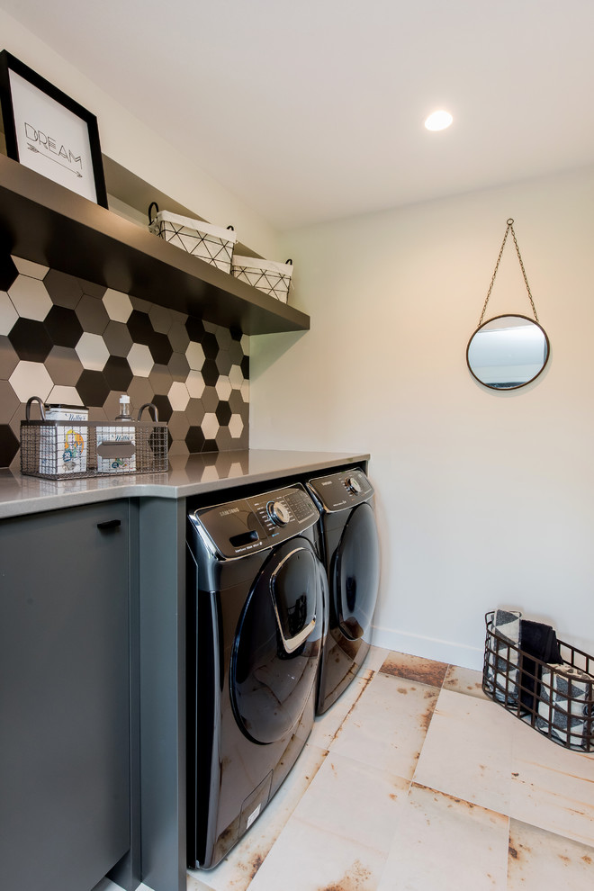 Dedicated laundry room - mid-sized transitional single-wall ceramic tile and multicolored floor dedicated laundry room idea with flat-panel cabinets, gray cabinets, laminate countertops, white walls, a side-by-side washer/dryer and gray countertops