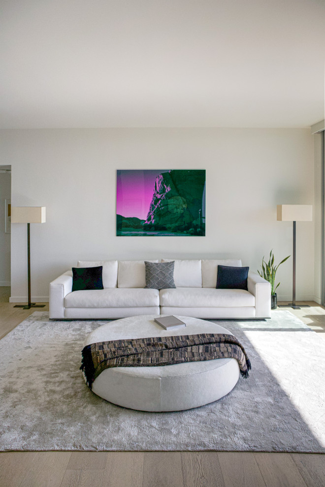 Photo of a large contemporary living room in Los Angeles with white walls and medium hardwood floors.