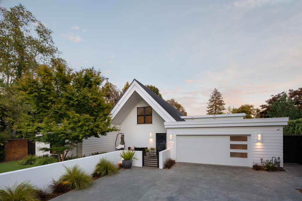 Diseño de fachada de casa blanca y negra vintage grande a niveles con revestimientos combinados, tejado plano, tejado de metal y panel y listón