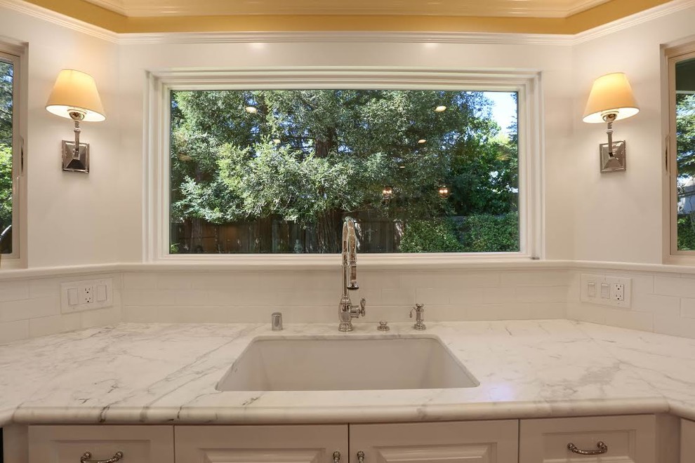 Enclosed kitchen - mid-sized transitional u-shaped light wood floor enclosed kitchen idea in San Francisco with an undermount sink, beaded inset cabinets, white cabinets, marble countertops, white backsplash, subway tile backsplash, white appliances and an island