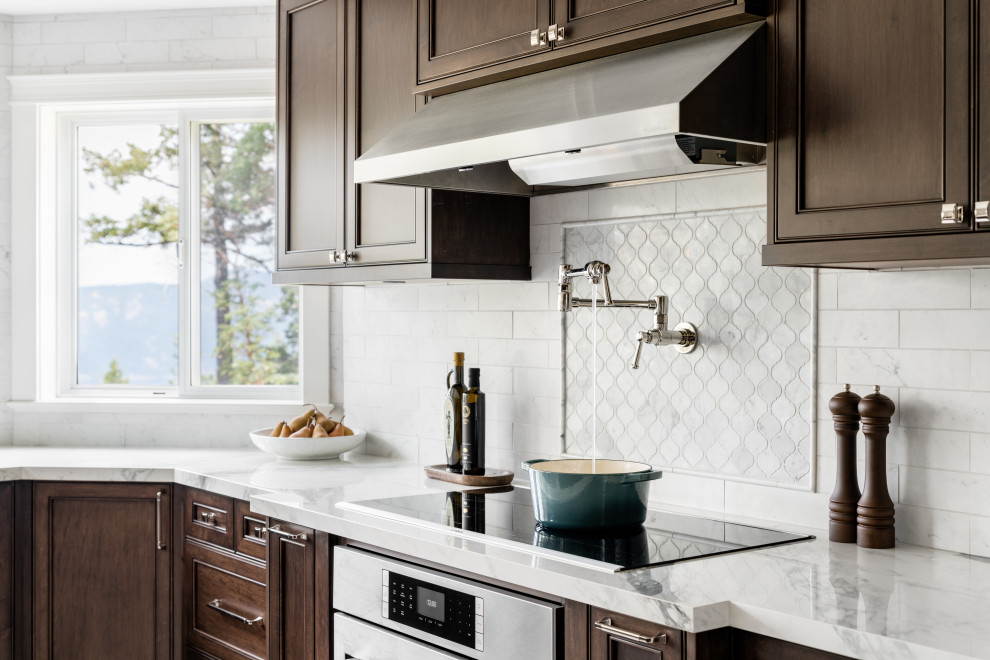 Example of a large transitional u-shaped porcelain tile and white floor open concept kitchen design in Vancouver with an undermount sink, recessed-panel cabinets, dark wood cabinets, quartz countertops, white backsplash, ceramic backsplash, stainless steel appliances, an island and white countertops