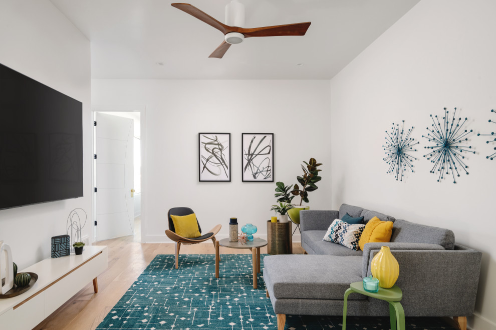 Family room - mid-sized 1960s enclosed medium tone wood floor and beige floor family room idea in San Francisco with white walls and a wall-mounted tv