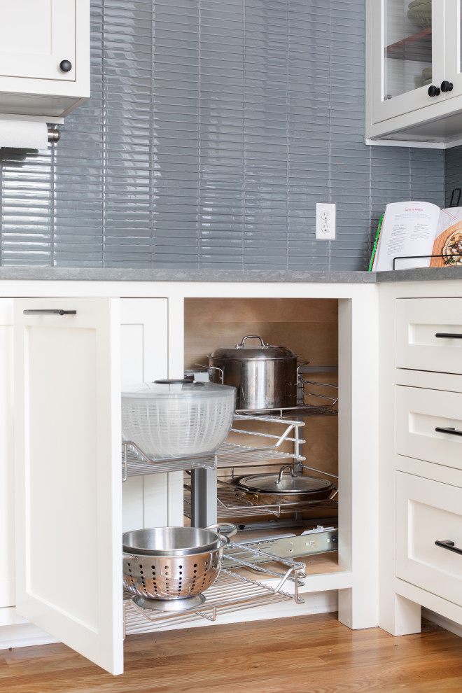 Inspiration for a mid-sized transitional u-shaped light wood floor and brown floor eat-in kitchen remodel in Austin with an undermount sink, shaker cabinets, white cabinets, quartz countertops, blue backsplash, glass tile backsplash, stainless steel appliances, no island and gray countertops