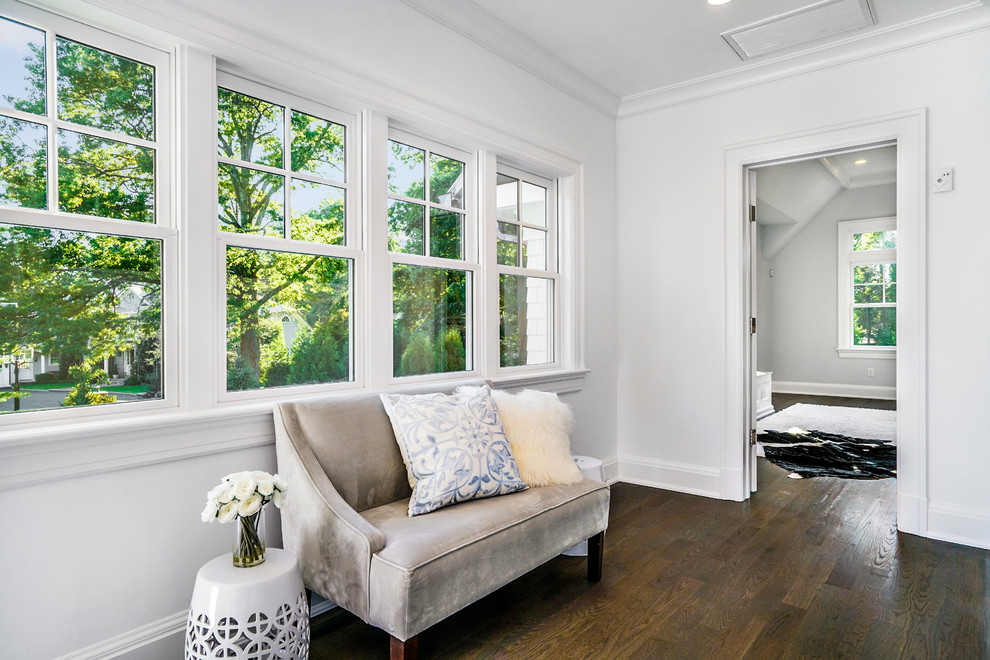 Inspiration for an expansive transitional master bedroom in New York with white walls, medium hardwood floors, a standard fireplace and a wood fireplace surround.