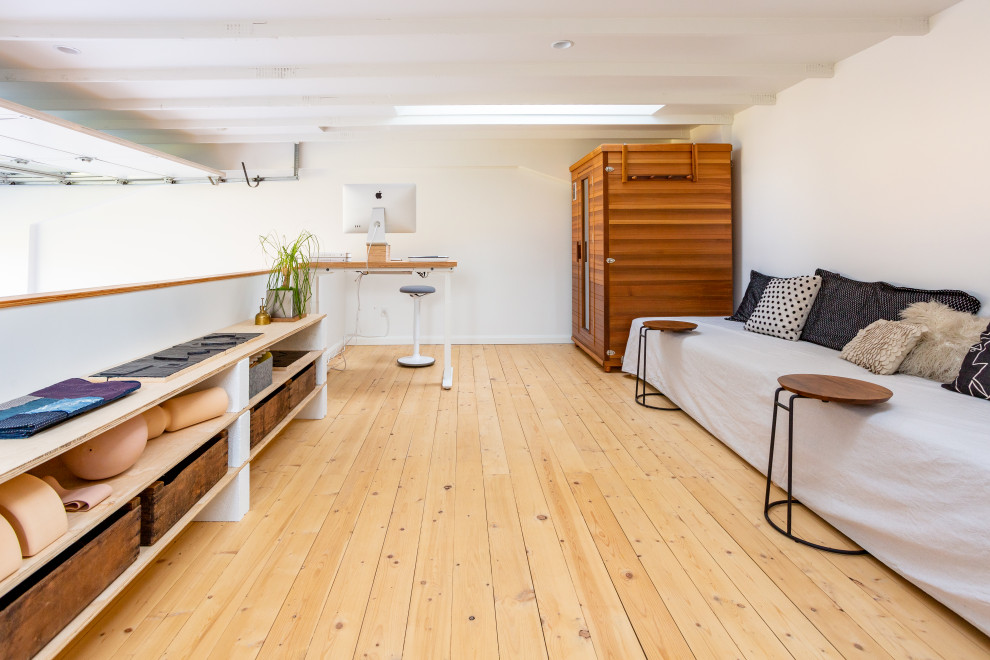 Foto de estudio industrial de tamaño medio con paredes blancas, suelo de madera clara, escritorio independiente, suelo marrón y vigas vistas