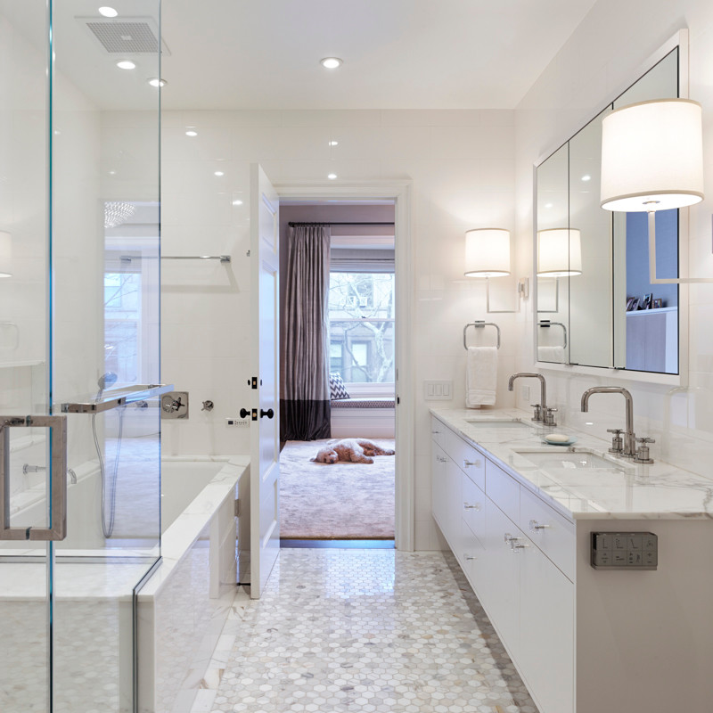 Design ideas for a large transitional master bathroom in New York with flat-panel cabinets, white cabinets, a drop-in tub, a corner shower, a two-piece toilet, white walls, marble floors, an undermount sink, marble benchtops and a hinged shower door.