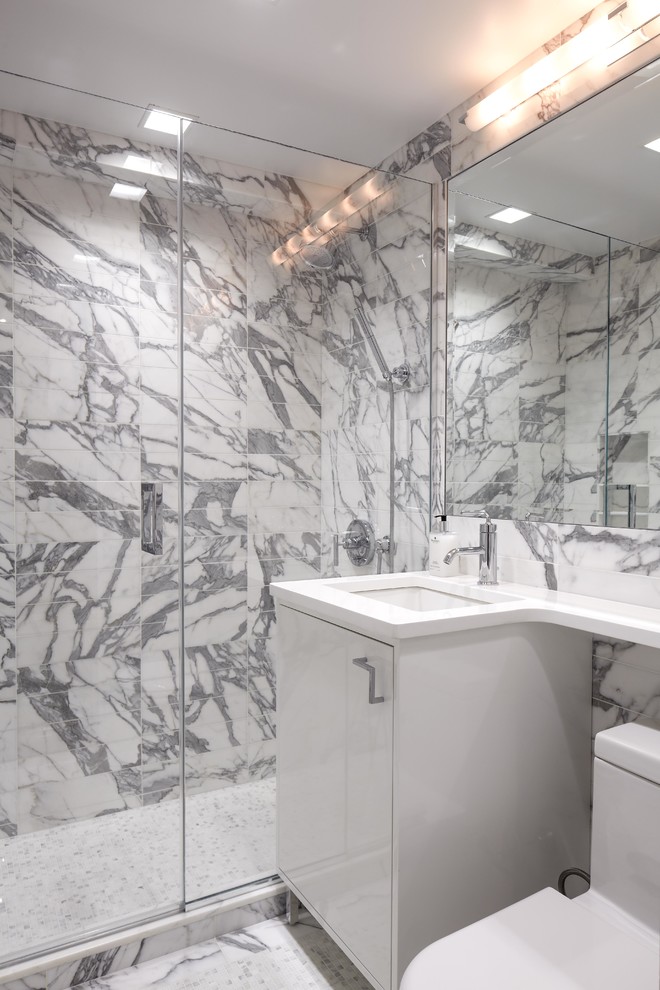 Example of a trendy white tile alcove shower design in New York with an undermount sink, flat-panel cabinets, white cabinets and a one-piece toilet