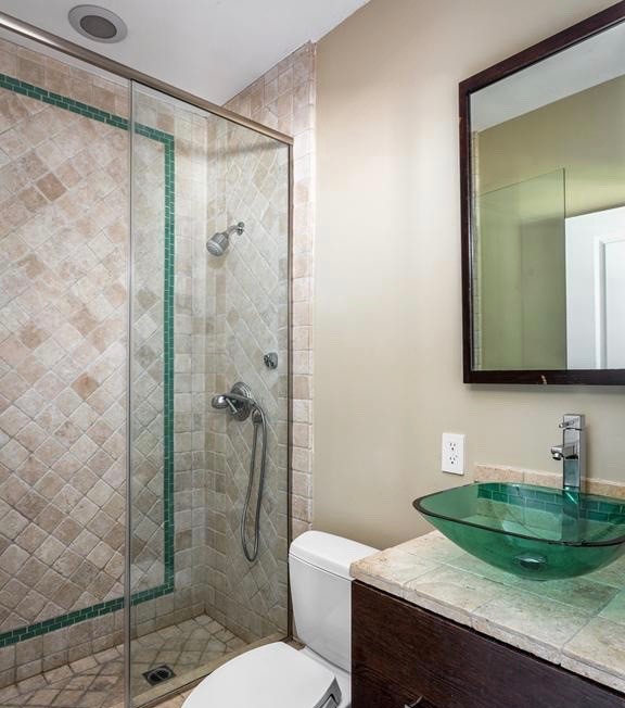 Mid-sized mediterranean 3/4 bathroom in Los Angeles with dark wood cabinets, a drop-in tub, beige tile, beige walls, a vessel sink, beige floor and a hinged shower door.