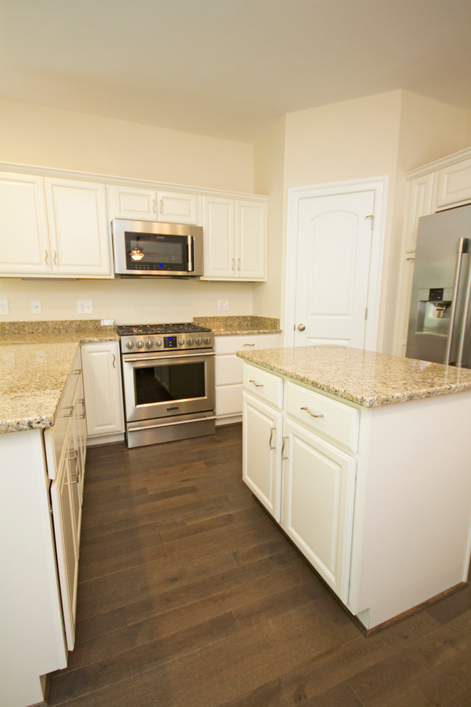 Eat-in kitchen - large transitional u-shaped dark wood floor eat-in kitchen idea in Richmond with a double-bowl sink, raised-panel cabinets, white cabinets, granite countertops, beige backsplash, stainless steel appliances and an island