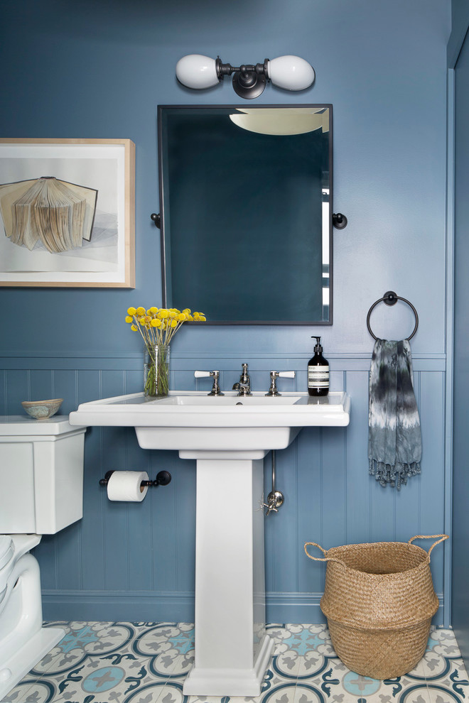 Inspiration for a small transitional multicolored floor powder room remodel in New York with a two-piece toilet, blue walls and a pedestal sink