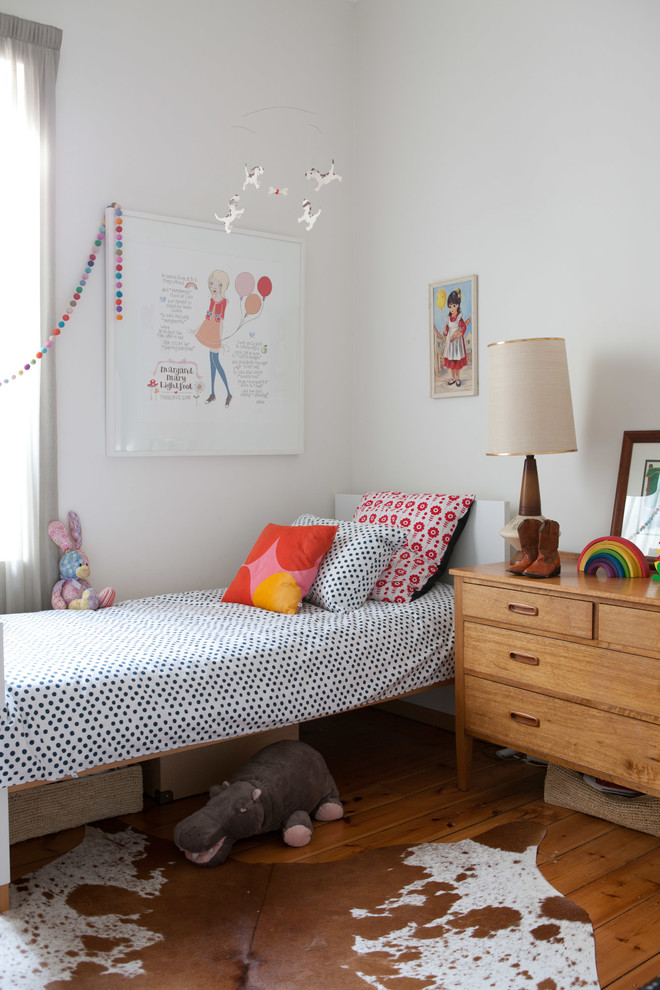This is an example of an eclectic kids' bedroom for kids 4-10 years old and girls in Adelaide with white walls and medium hardwood floors.