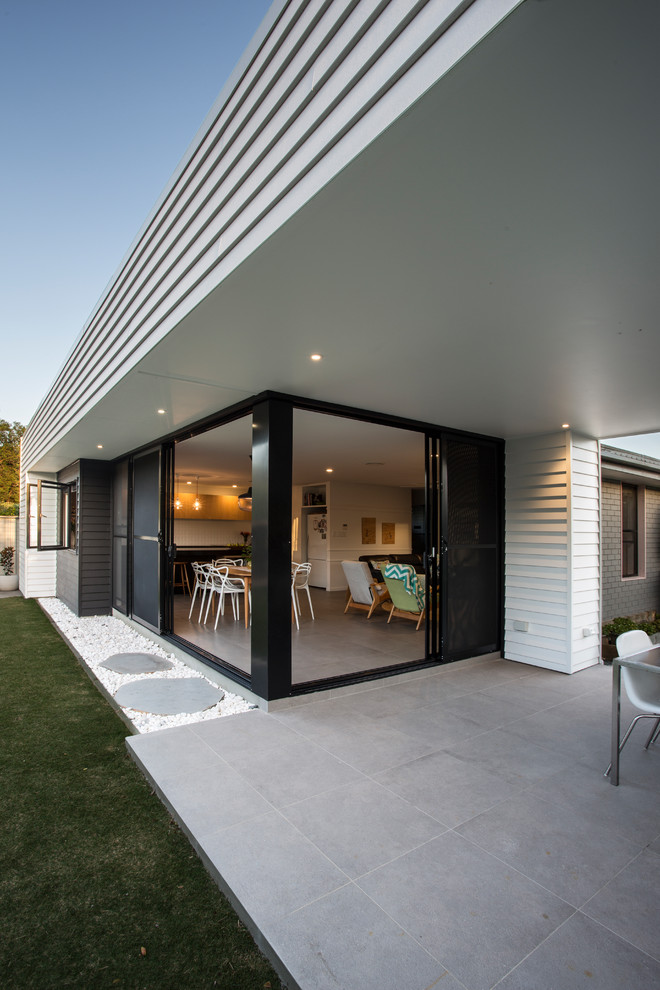 Photo of a small contemporary backyard deck in Gold Coast - Tweed with a roof extension.