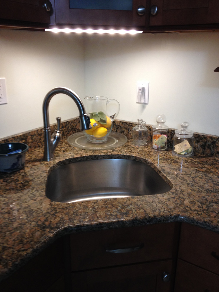 Eat-in kitchen - small transitional l-shaped linoleum floor eat-in kitchen idea in Boston with an undermount sink, recessed-panel cabinets, medium tone wood cabinets, granite countertops, stainless steel appliances and no island