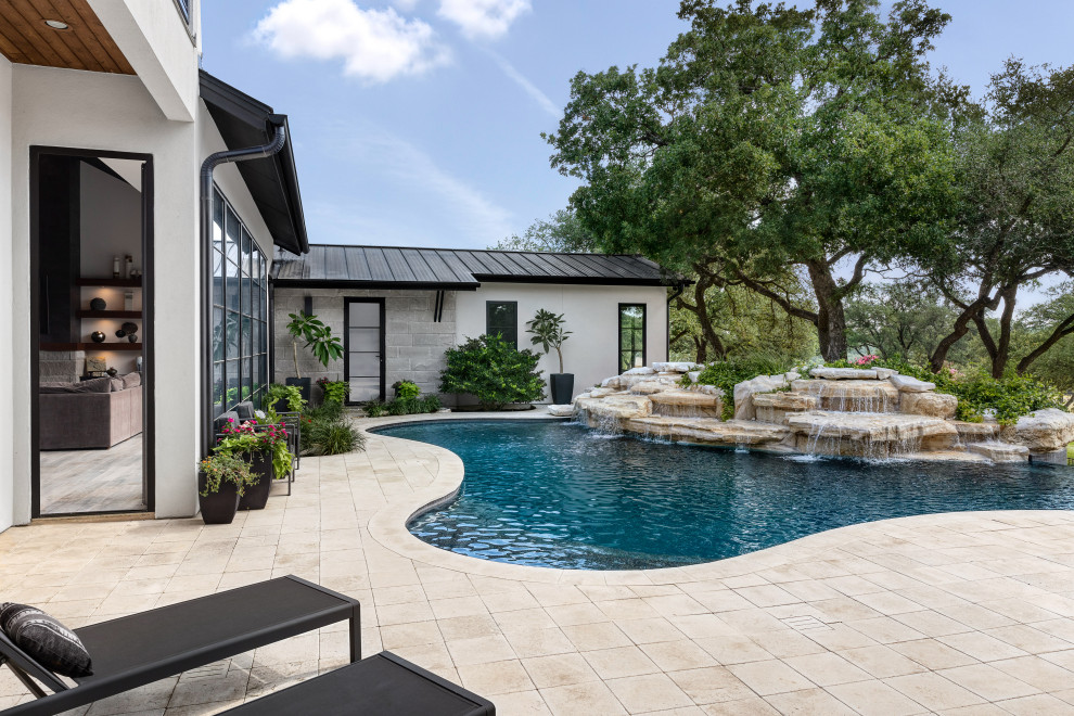 Inspiration for a modern back custom shaped swimming pool in Austin with with pool landscaping.