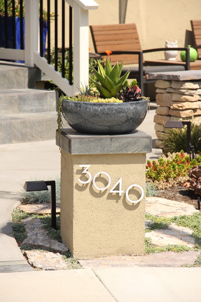 This is an example of a contemporary front yard xeriscape in San Diego with concrete pavers.
