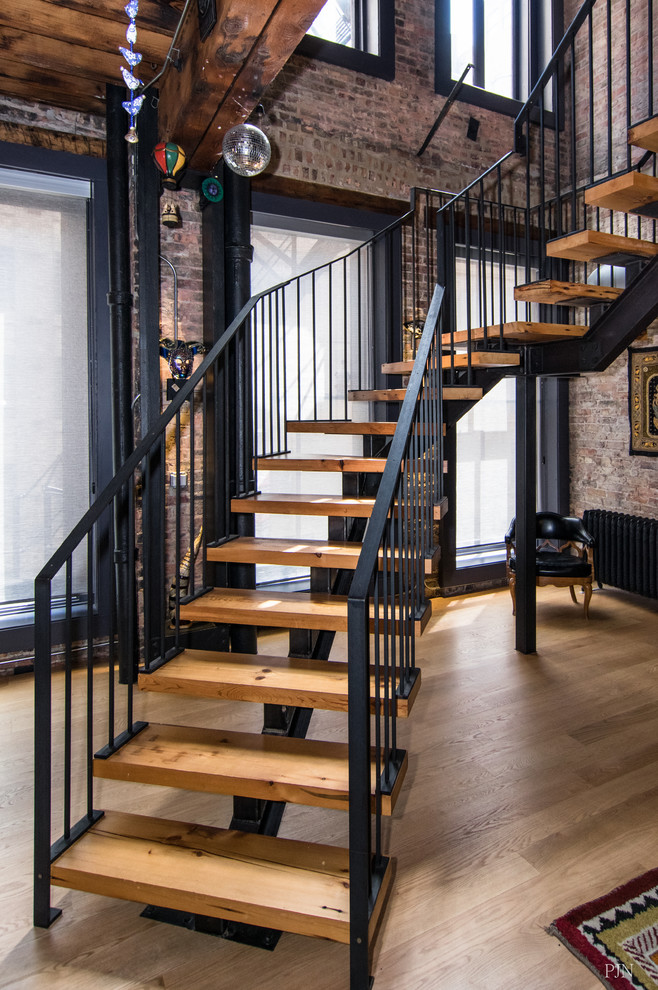 Photo of an eclectic wood floating staircase in Chicago with open risers and metal railing.