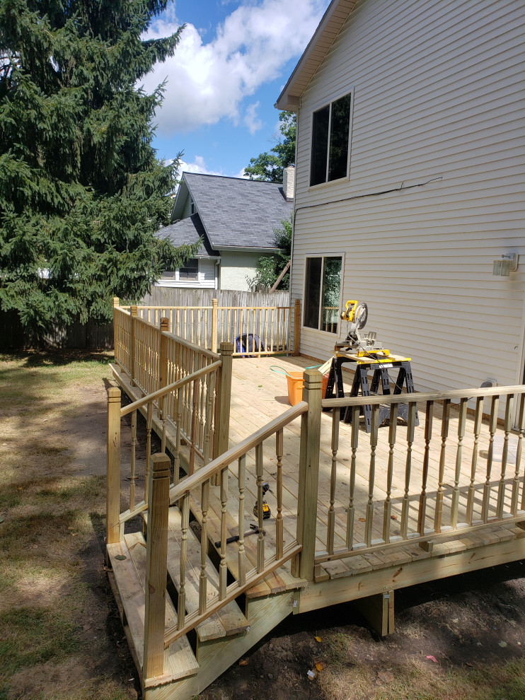 Inspiration for a backyard ground level wood railing deck remodel
