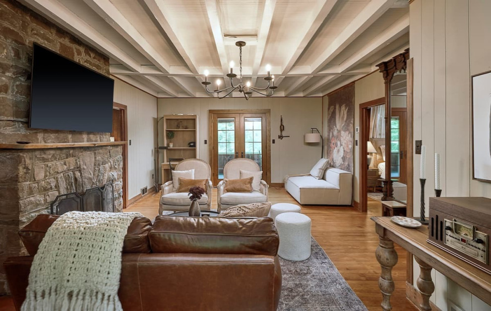 This is an example of a mid-sized country living room in Other with medium hardwood floors, a standard fireplace, a stone fireplace surround and a wall-mounted tv.