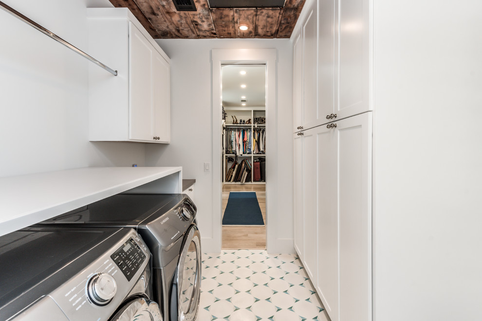Mid-sized country galley dedicated laundry room in Houston with shaker cabinets, white cabinets, quartzite benchtops, white walls, porcelain floors, a side-by-side washer and dryer, white floor and grey benchtop.