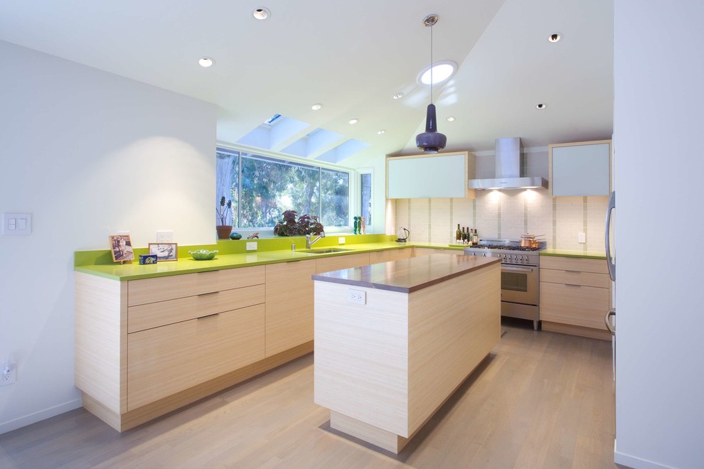 Inspiration for a large contemporary u-shaped eat-in kitchen in San Francisco with a drop-in sink, quartz benchtops, green splashback, ceramic splashback, stainless steel appliances, light hardwood floors, with island, flat-panel cabinets, light wood cabinets and green benchtop.
