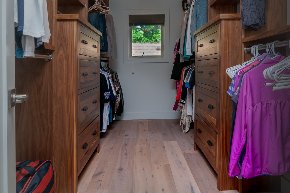 Mid-sized traditional gender-neutral walk-in wardrobe in Other with shaker cabinets, medium wood cabinets, light hardwood floors and beige floor.