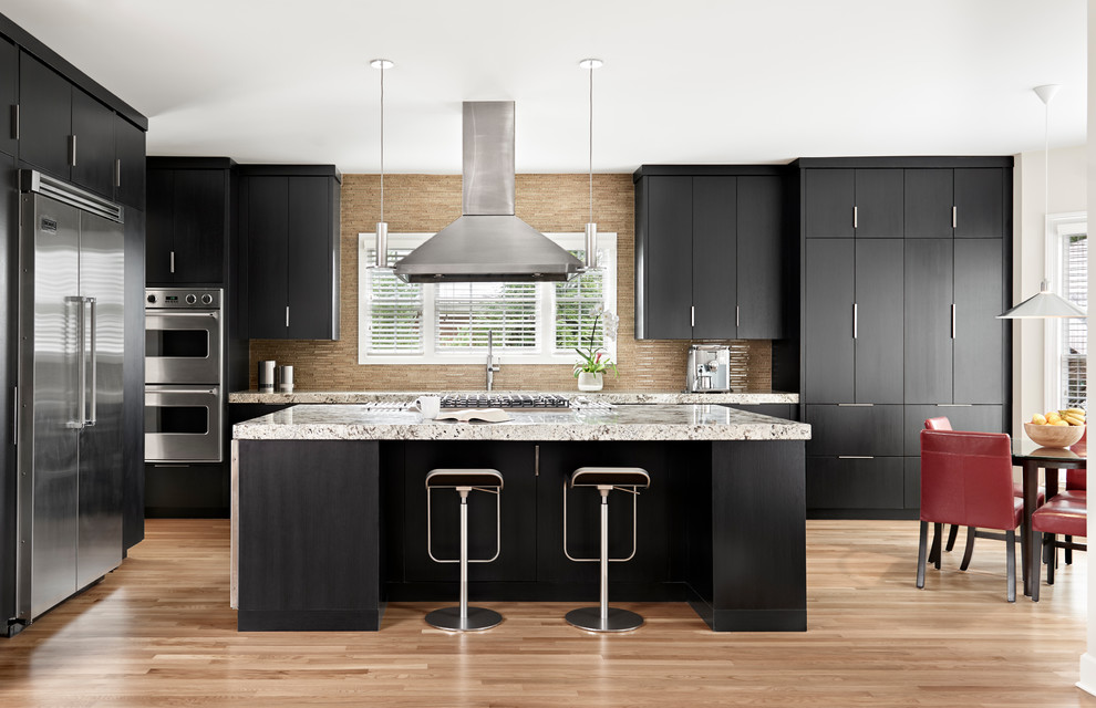Design ideas for a contemporary eat-in kitchen in Nashville with flat-panel cabinets, black cabinets, beige splashback, stainless steel appliances, light hardwood floors, with island, beige floor and multi-coloured benchtop.