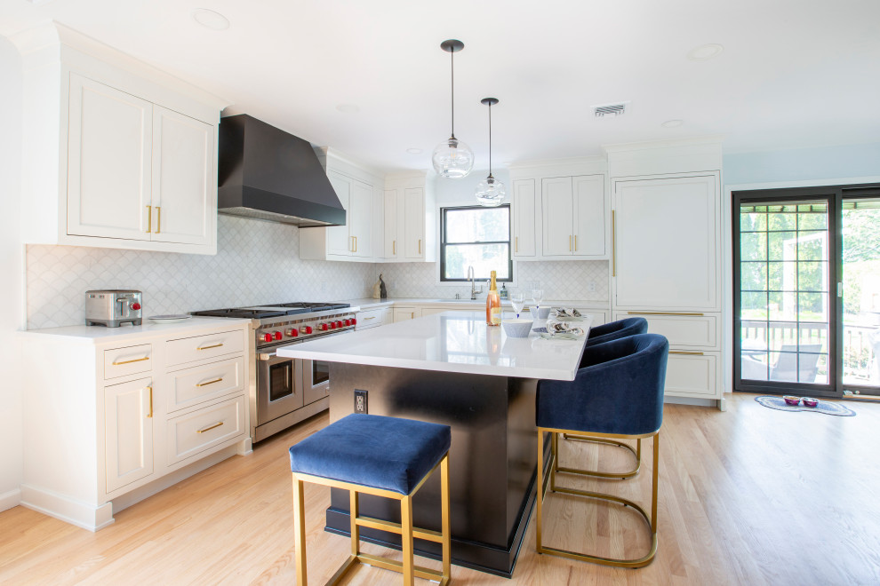 Photo of a mid-sized transitional l-shaped eat-in kitchen in New York with an integrated sink, shaker cabinets, white cabinets, quartz benchtops, white splashback, panelled appliances, light hardwood floors, with island and white benchtop.