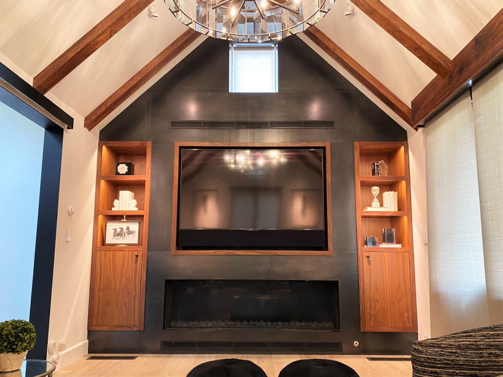 Imagen de sala de estar cerrada y abovedada actual de tamaño medio con paredes negras, suelo de madera clara, chimenea lineal, marco de chimenea de metal y pared multimedia