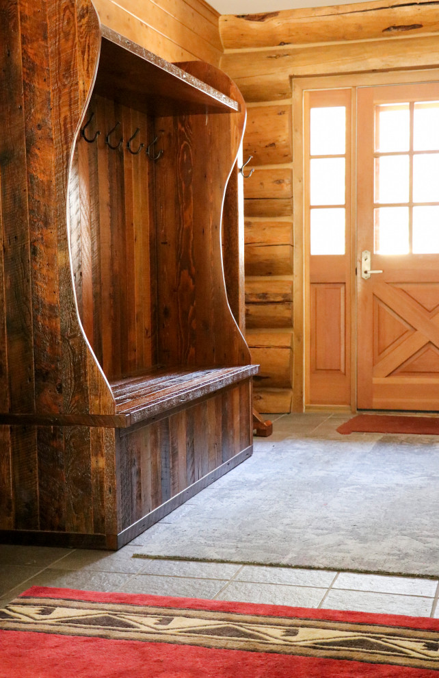 Inspiration for a small rustic slate floor, gray floor and wood wall entry hall remodel with brown walls and a light wood front door