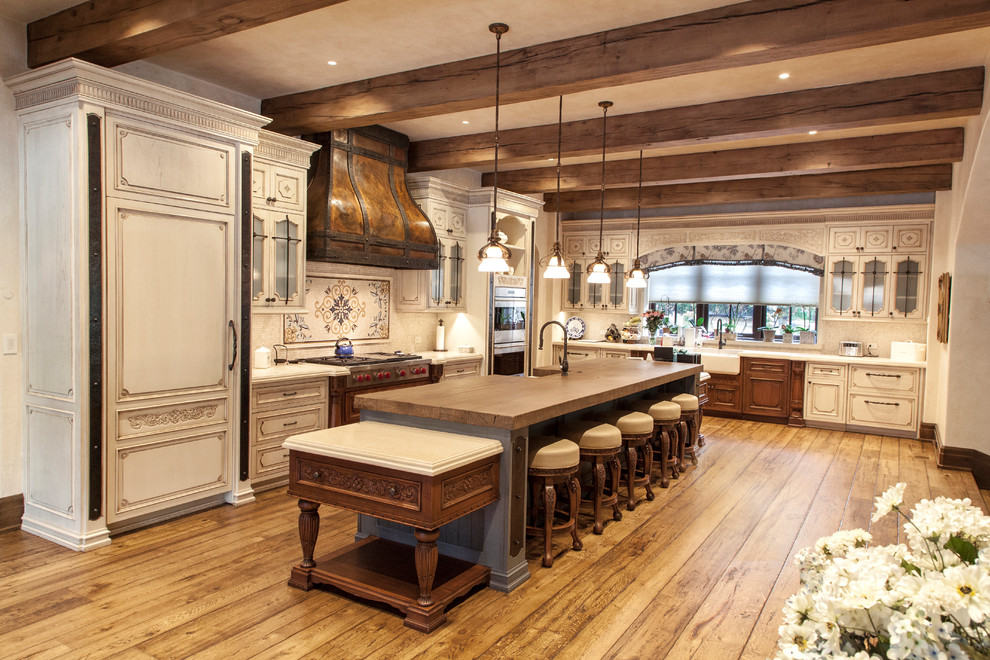 Inspiration for an expansive country l-shaped open plan kitchen in New York with raised-panel cabinets, white cabinets, with island, beige splashback, mosaic tile splashback, a farmhouse sink, wood benchtops, stainless steel appliances, painted wood floors, yellow floor and brown benchtop.