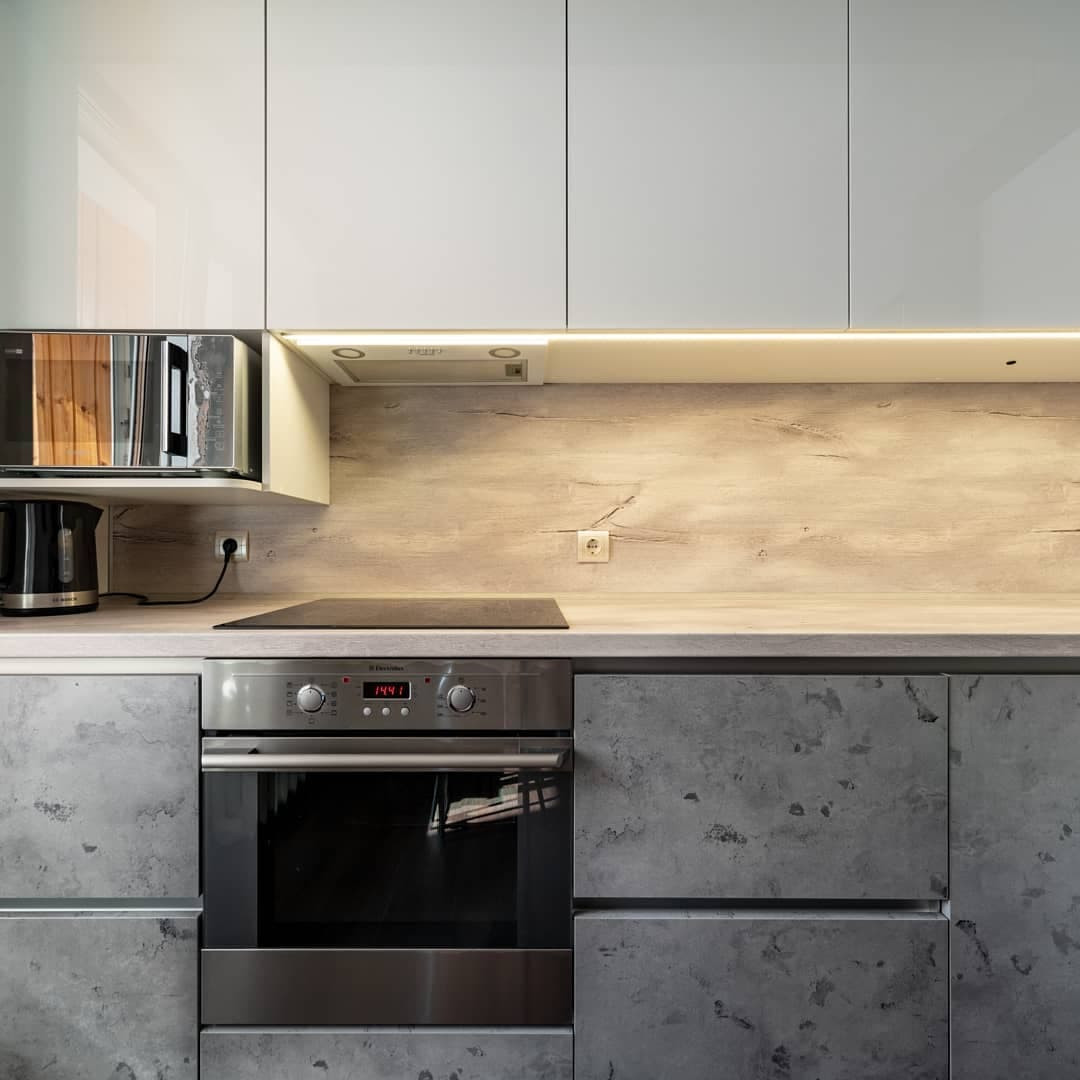 Угловая встроенная кухня с белыми глянцевыми и каменными фасадами