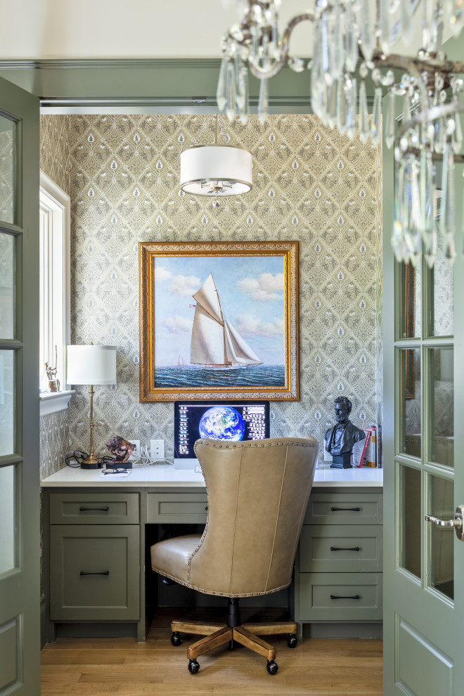 Imagen de despacho tradicional pequeño con paredes multicolor, suelo de madera clara, escritorio empotrado, suelo marrón y papel pintado