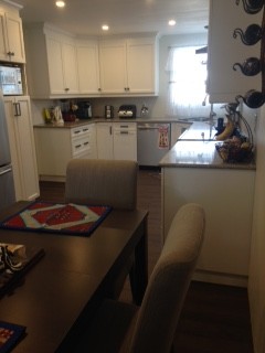 Eat-in kitchen - mid-sized transitional u-shaped bamboo floor eat-in kitchen idea in Ottawa with flat-panel cabinets, yellow cabinets, quartz countertops and no island