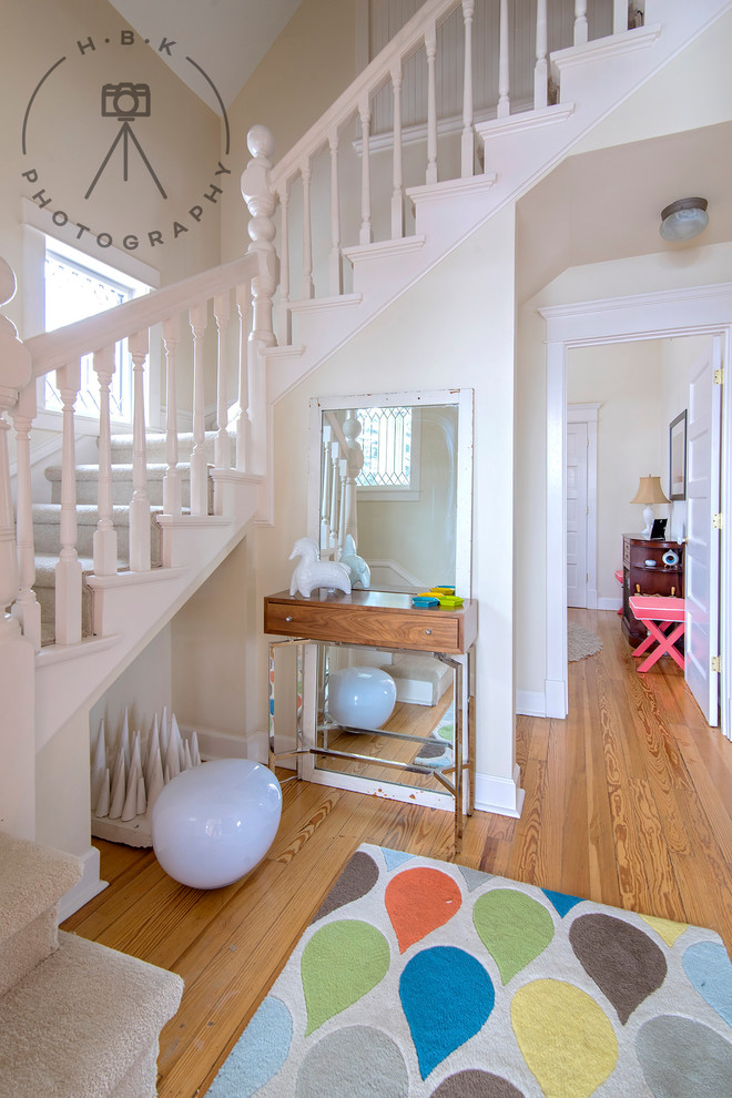Inspiration for a mid-sized light wood floor and yellow floor entry hall remodel with white walls