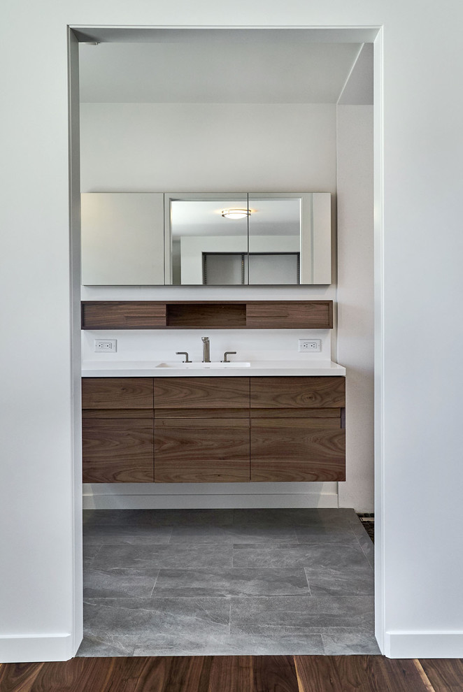 Design ideas for a mid-sized modern master bathroom in San Francisco with flat-panel cabinets, brown cabinets, an alcove shower, a one-piece toilet, white tile, stone slab, white walls, an integrated sink, engineered quartz benchtops and white benchtops.