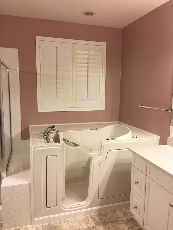 This is an example of a mid-sized transitional master bathroom in Orange County with raised-panel cabinets, white cabinets, a corner tub, a corner shower, white tile, porcelain tile, brown walls, porcelain floors, an undermount sink, quartzite benchtops, brown floor and a sliding shower screen.