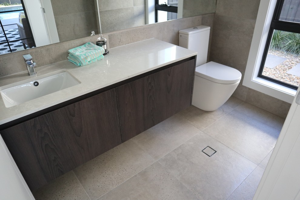 Design ideas for a mid-sized contemporary 3/4 bathroom in Sydney with a one-piece toilet, beige tile, porcelain tile, beige walls, porcelain floors, a drop-in sink and beige floor.