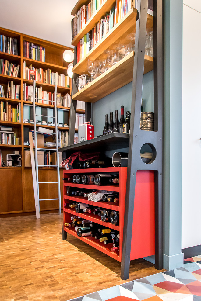 Inspiration for a small eclectic wine cellar in Milan with medium hardwood floors, storage racks and brown floor.
