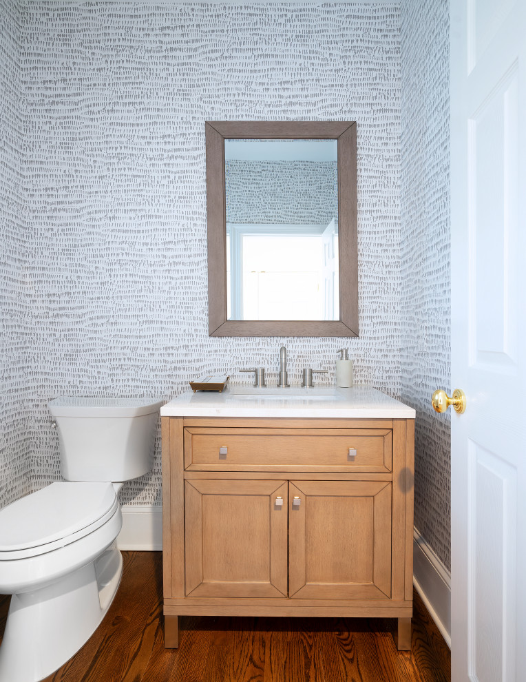 Inspiration for a transitional powder room in Philadelphia with shaker cabinets, light wood cabinets, dark hardwood floors, a console sink, marble benchtops, brown floor, white benchtops, a freestanding vanity and wallpaper.