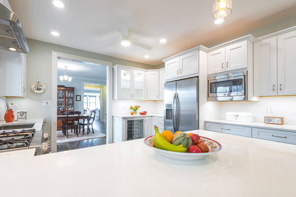 Mid-sized transitional galley dark wood floor enclosed kitchen photo in Chicago with an undermount sink, recessed-panel cabinets, white cabinets, quartz countertops, white backsplash, subway tile backsplash, stainless steel appliances and no island