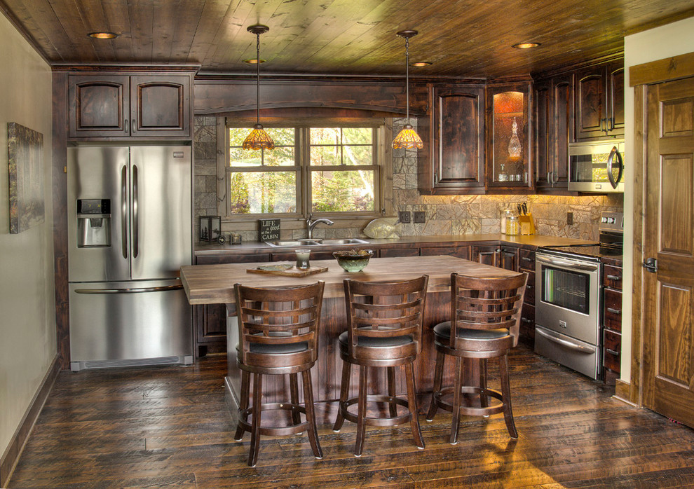 Inspiration for a country l-shaped kitchen in Minneapolis with a double-bowl sink, raised-panel cabinets, dark wood cabinets, stainless steel appliances, dark hardwood floors and with island.