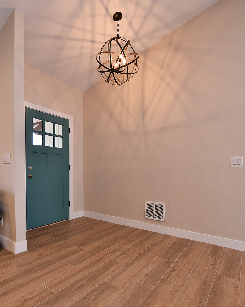 Photo of a mid-sized country foyer in Phoenix with black walls, light hardwood floors, a single front door, a blue front door and brown floor.